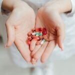 Close-up of a person holding various pills and capsules in their hands, symbolizing healthcare and medicine.
